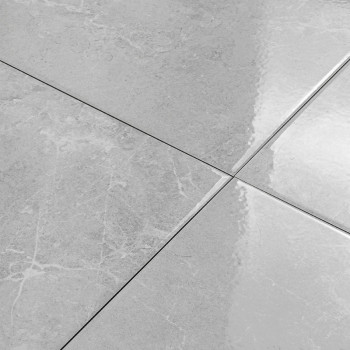 Quatre carreaux de céramique gris brillants forment une grille lisse et entrecroisée, réfléchissant la lumière et révélant de su