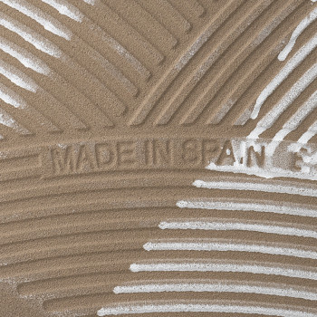 Le carreau, avec une surface texturée, affiche le texte « MADE IN SPAIN » sur un fond de lignes tourbillonnantes en relief.