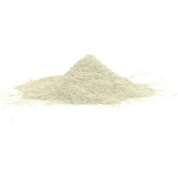 Un petit tas de poudre gris clair repose sur une surface unie et blanche, suggérant un matériau de construction ou d'artisanat.